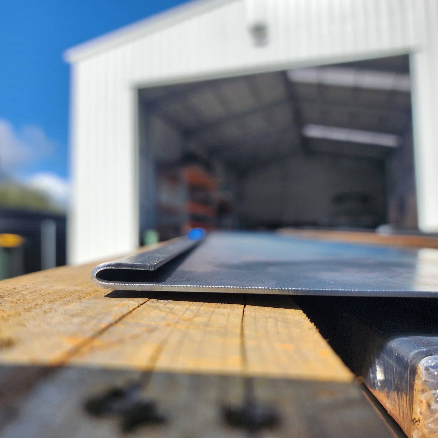 Stacked 1.6mm Corten edging plates on wood